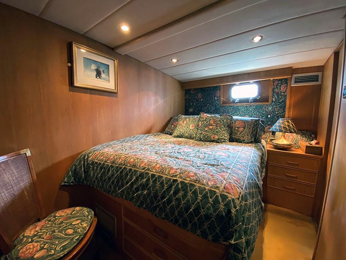 a bedroom with a bed and a dresser aboard COLUMBUS OF LYMINGTON Yacht for Sale