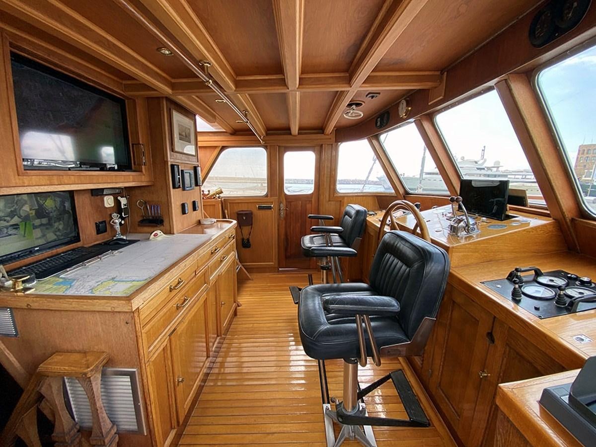 a kitchen with a bar and stools aboard COLUMBUS OF LYMINGTON Yacht for Sale