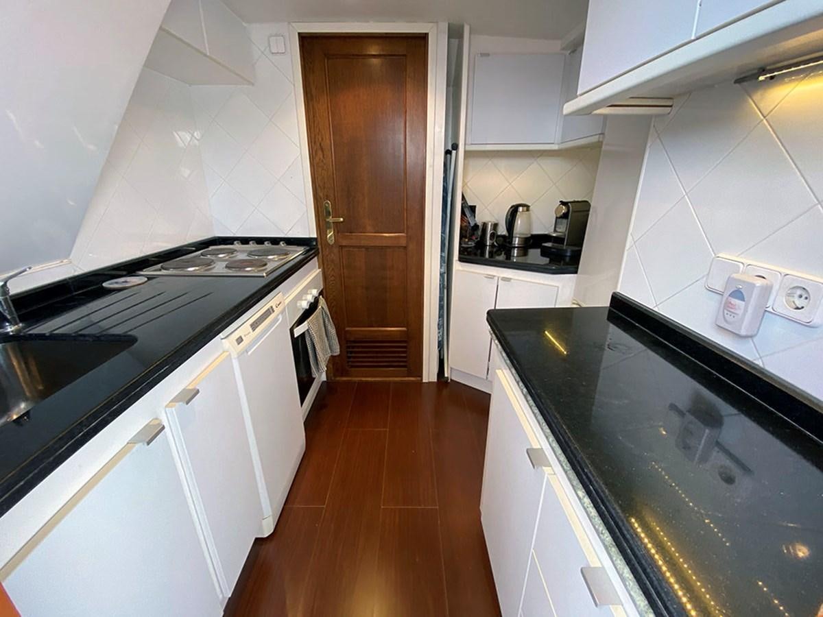 a kitchen with white cabinets aboard COLUMBUS OF LYMINGTON Yacht for Sale