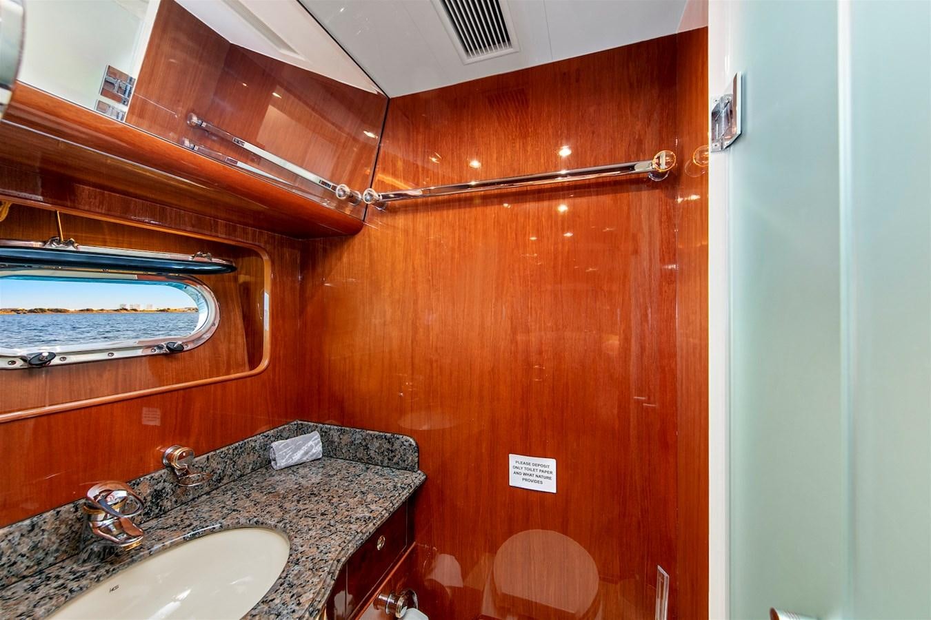 a bathroom with a sink and a wooden cabinet aboard PAPA'S PLACE Yacht for Sale