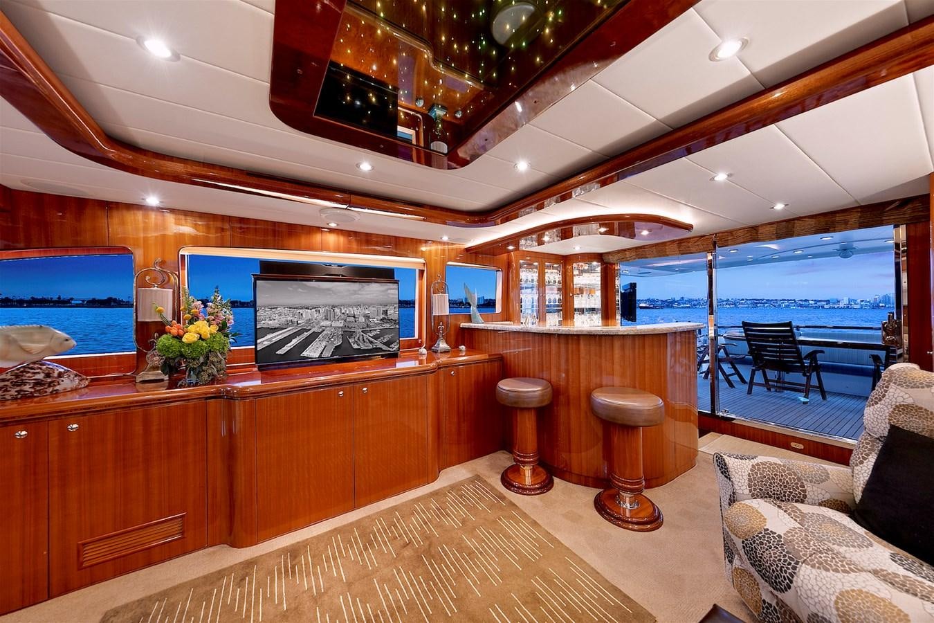 a room with a large window and a wood table with chairs and a tv on it aboard PAPA'S PLACE Yacht for Sale
