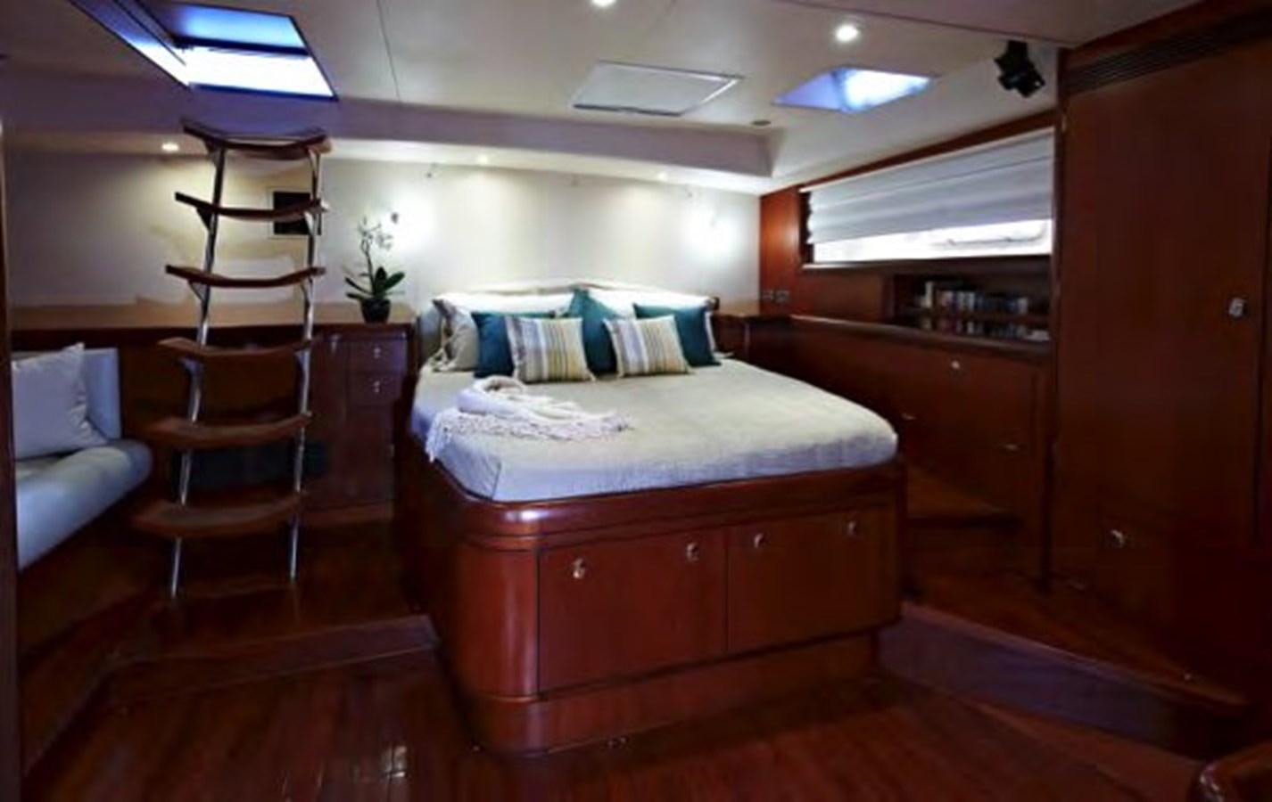 a bedroom with a bed and a chair aboard TILLYMINT Yacht for Sale