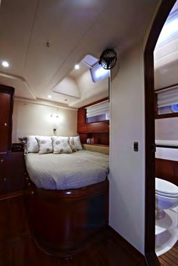 a bedroom with a bed and a window aboard TILLYMINT Yacht for Sale