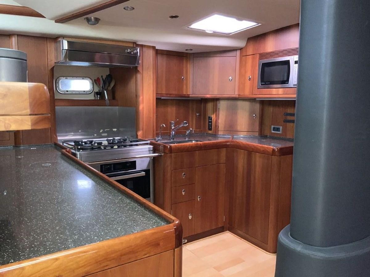 a kitchen with wooden cabinets aboard BILL AND ME Yacht for Sale