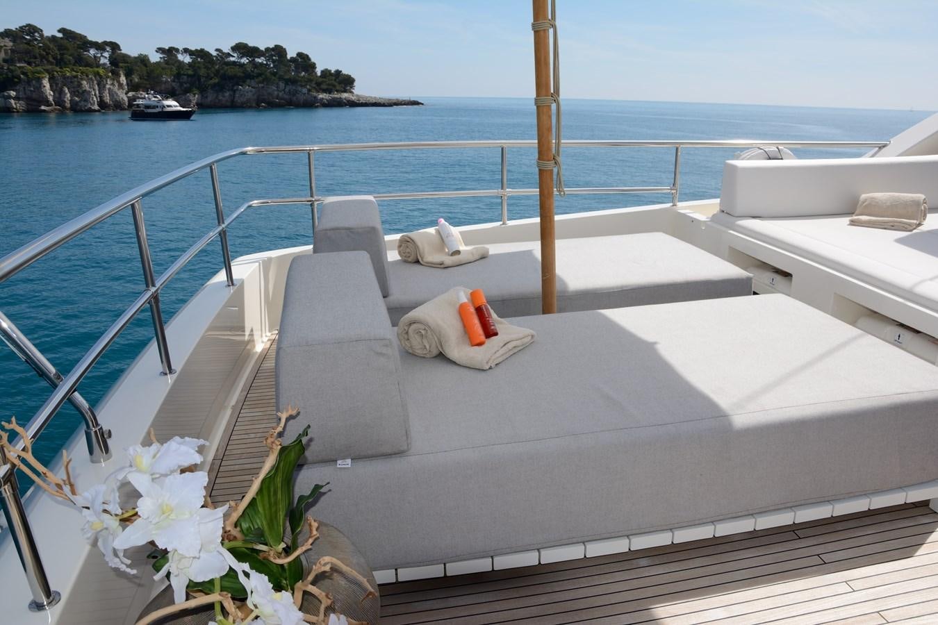 a white lounge chair on a balcony overlooking a body of water aboard COLUMBUS A Yacht for Sale
