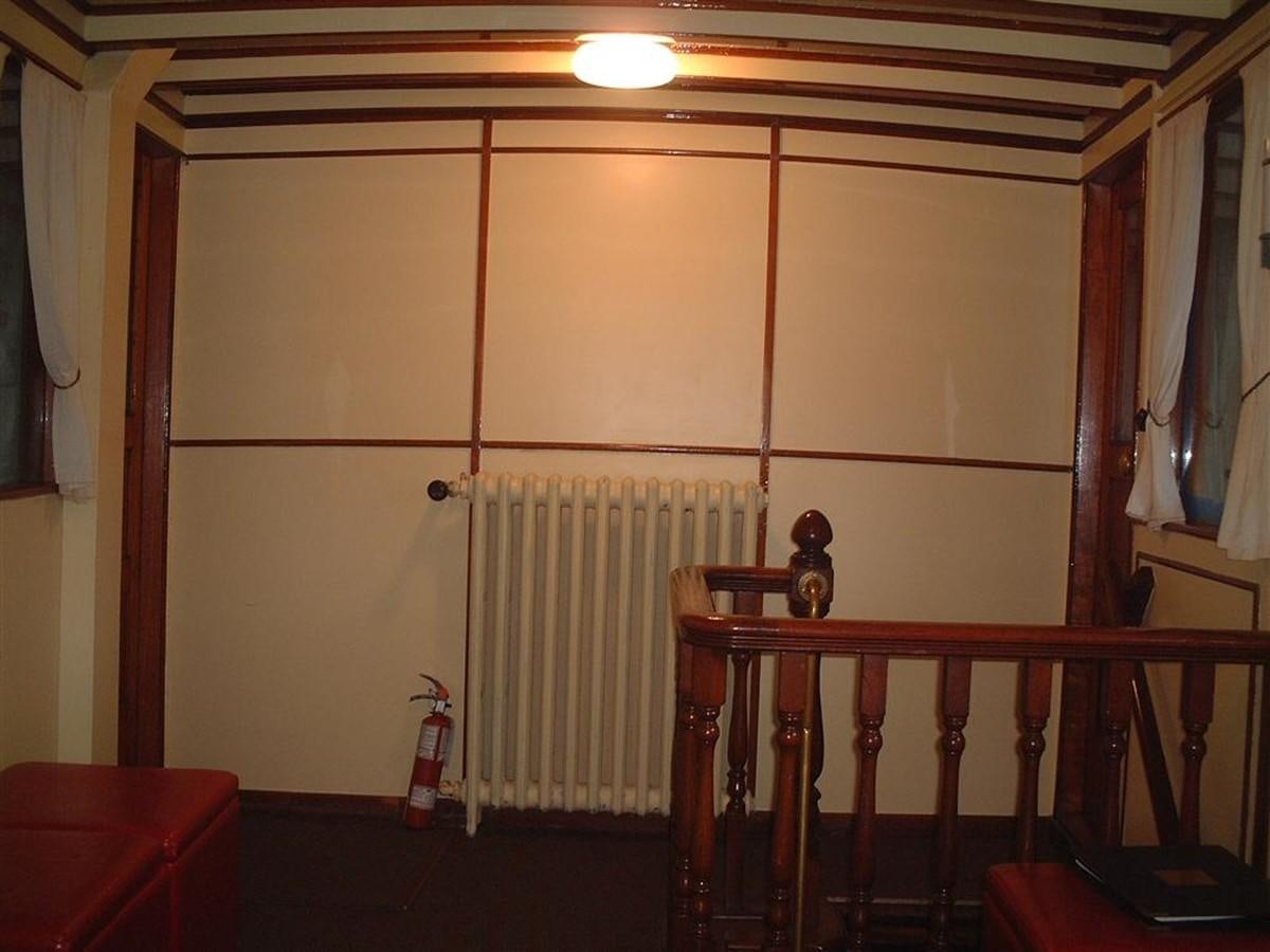 a room with a wood railing and a red couch and a white wall aboard SYRENE I Yacht for Sale