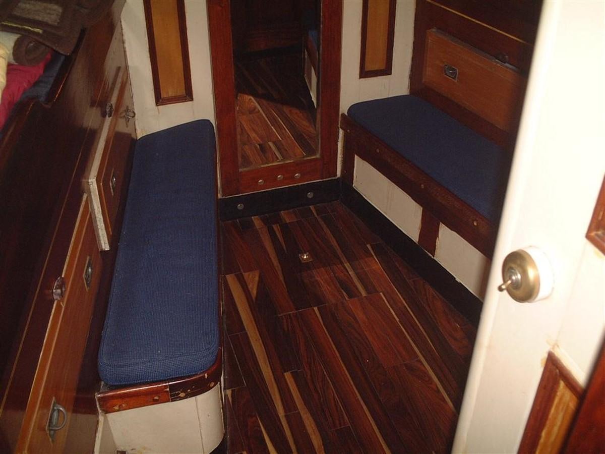 a room with a blue chair and a wood floor aboard SYRENE I Yacht for Sale