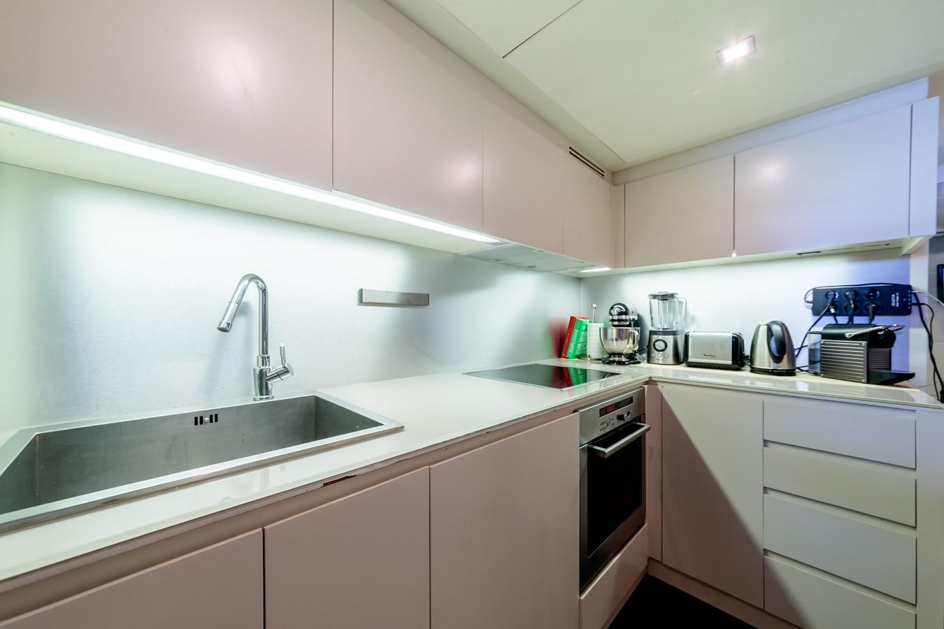 a kitchen with white cabinets aboard FOR EVER Yacht for Sale