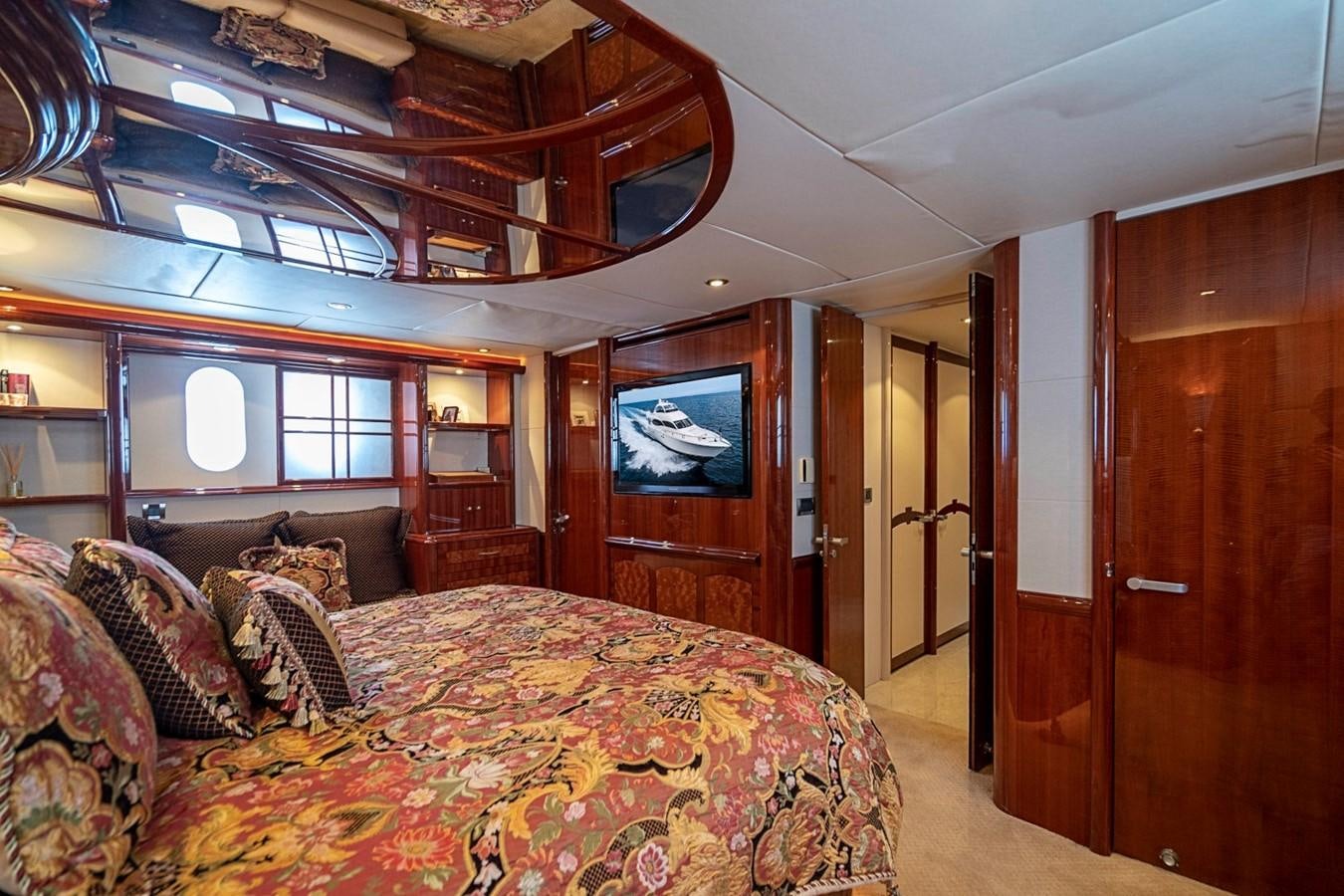 a bedroom with a bed and a wood door aboard RENDEZVOUS Yacht for Sale