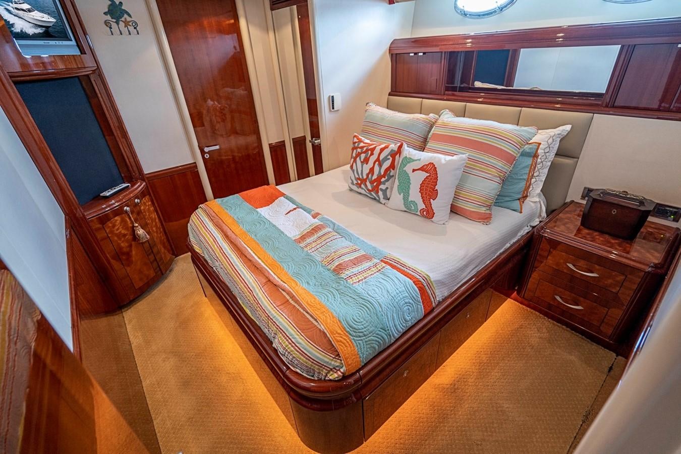 a bed with a blue and white comforter and pillows aboard RENDEZVOUS Yacht for Sale