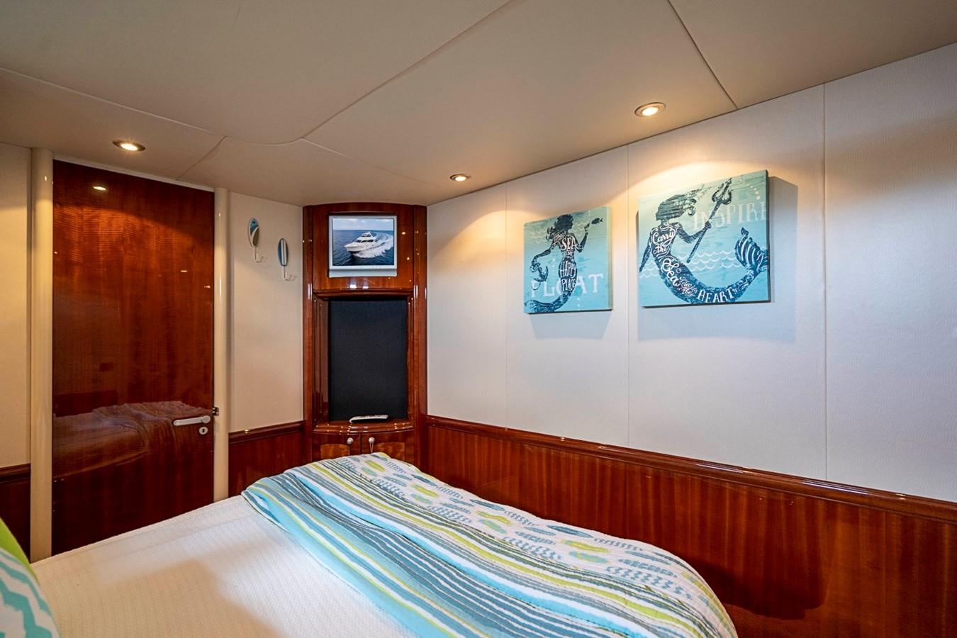 a bedroom with a bed and a television on the wall aboard RENDEZVOUS Yacht for Sale