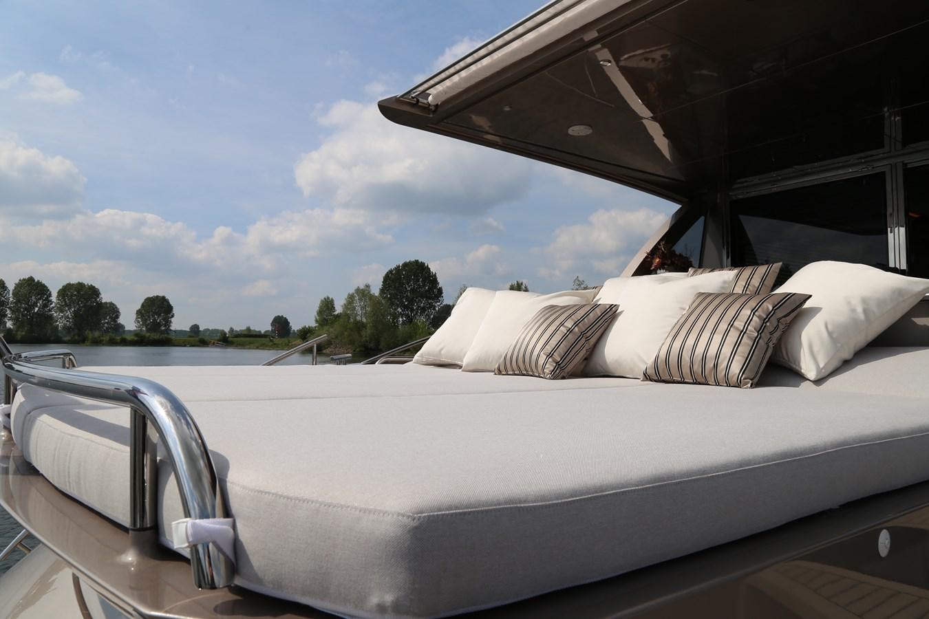 a white boat on a body of water with trees in the background aboard ALILEA Yacht for Sale