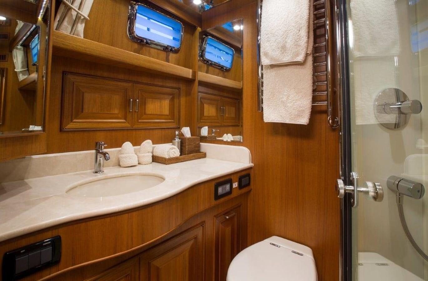 a bathroom with a sink and a tv on the wall aboard FLEMING 78 - NEW BUILD Yacht for Sale