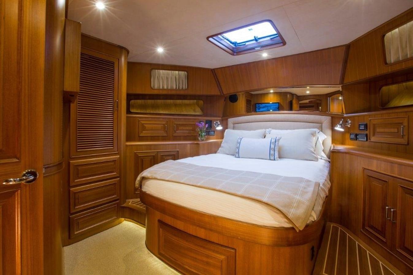 a bedroom with wooden cabinets aboard FLEMING 78 - NEW BUILD Yacht for Sale