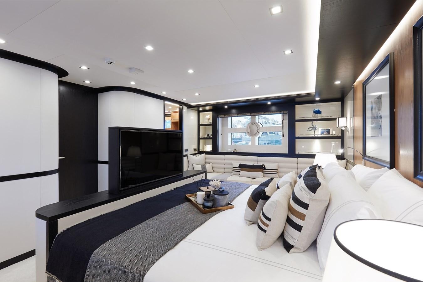 a modern bedroom with a large white bed and a flat screen tv aboard BERING 88/05 Yacht for Sale