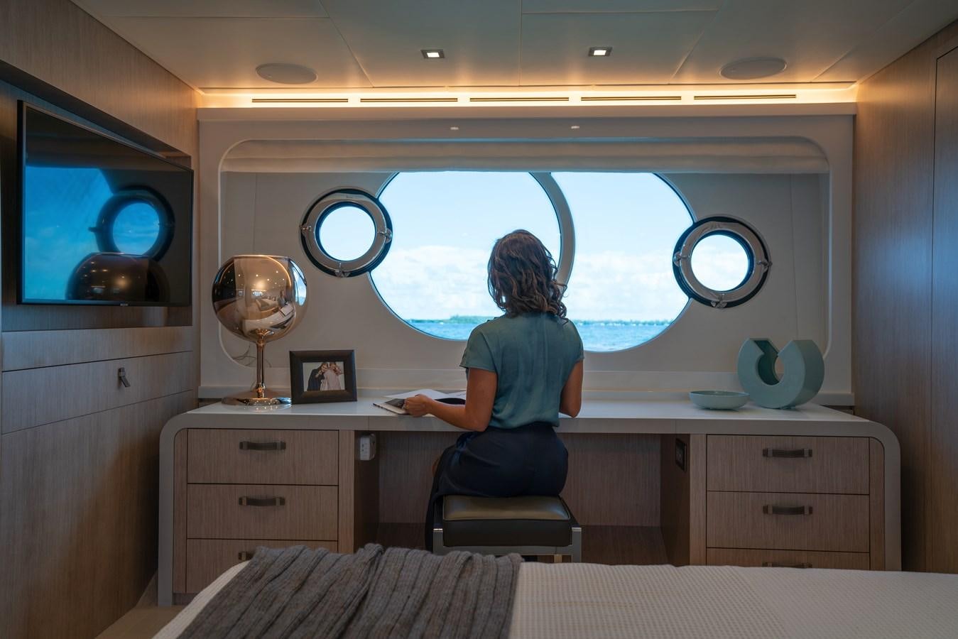 a person sitting in a chair in a room with a window aboard MONTE CARLO YACHTS MCY 76 Yacht for Sale