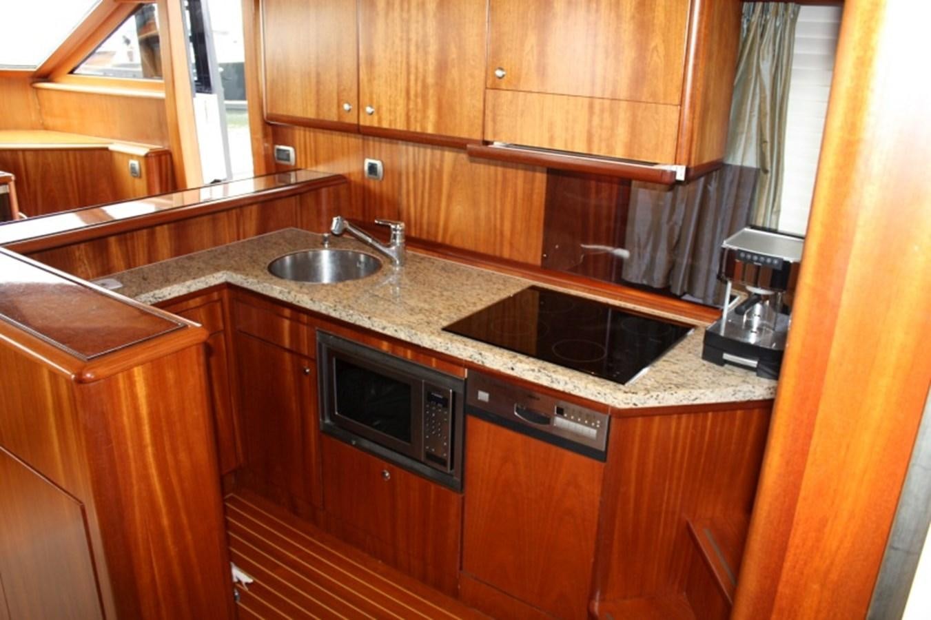 a kitchen with wooden cabinets aboard BOADICEA Yacht for Sale