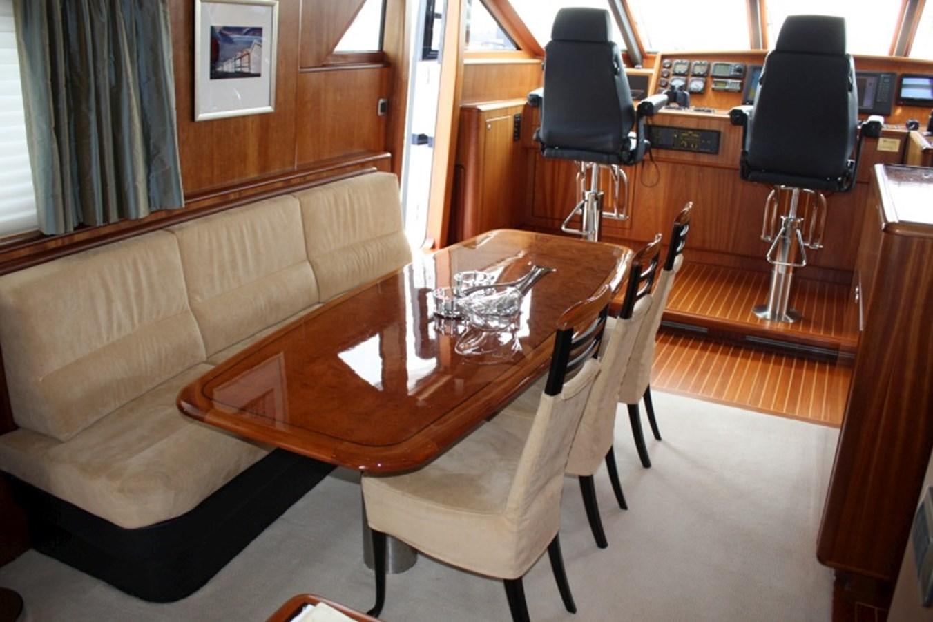 a room with a couch and a table with a lamp on it aboard BOADICEA Yacht for Sale