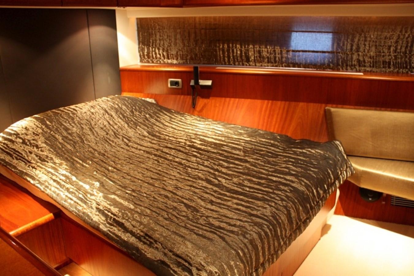 a bed with a couch and a chair in the background aboard BOADICEA Yacht for Sale