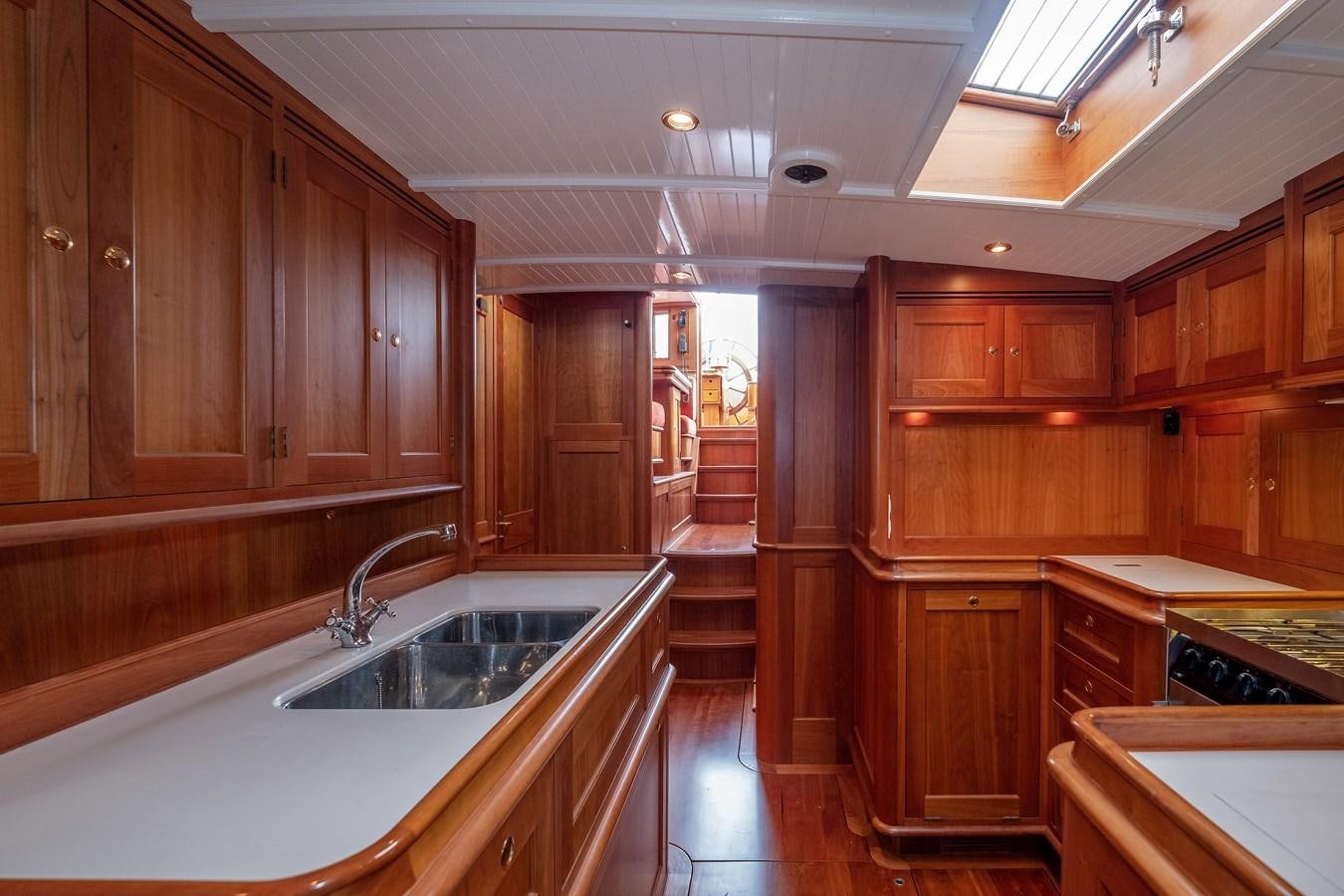 a kitchen with wooden cabinets aboard HOEK CLASSIC 73 DIXBAY Yacht for Sale