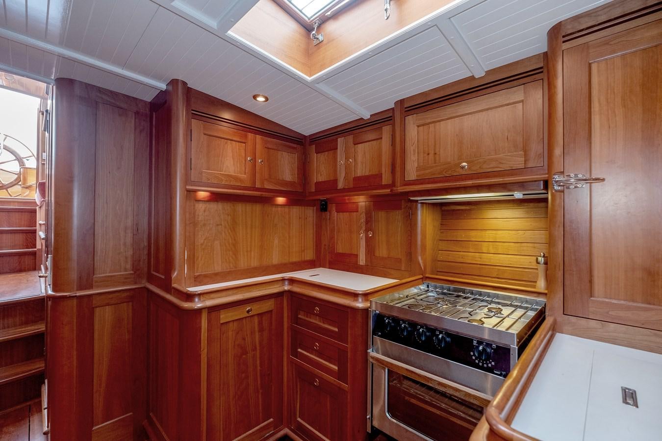 a kitchen with wooden cabinets aboard HOEK CLASSIC 73 DIXBAY Yacht for Sale