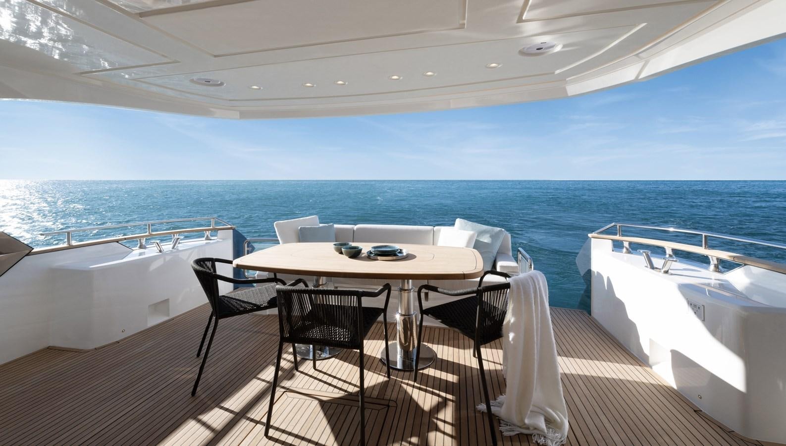 a table and chairs on a deck overlooking the ocean aboard MCY 70 SKYLOUNGE  Yacht for Sale