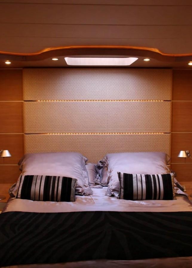 a bed with pillows and a wood headboard aboard FOX Yacht for Sale