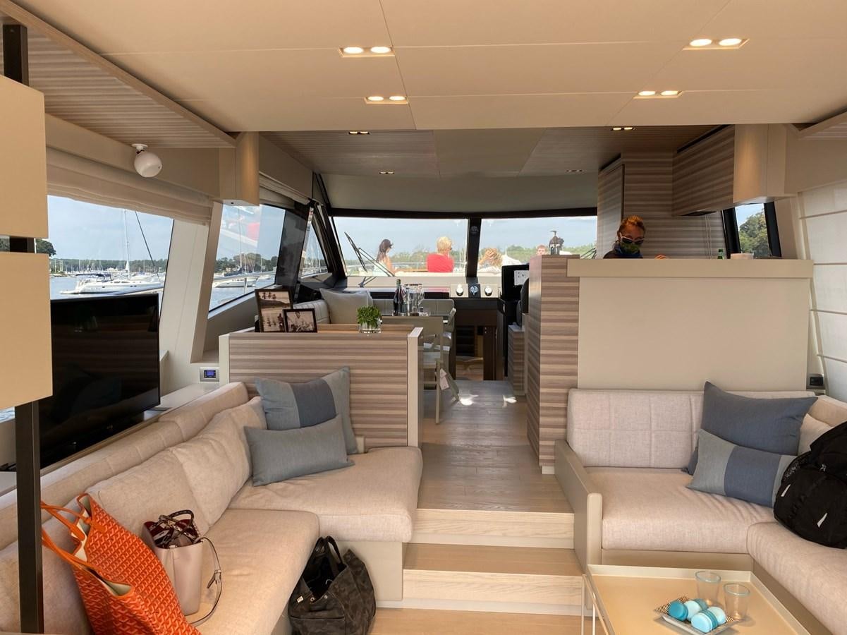 a living room with a large window aboard L’ABEILLE Yacht for Sale