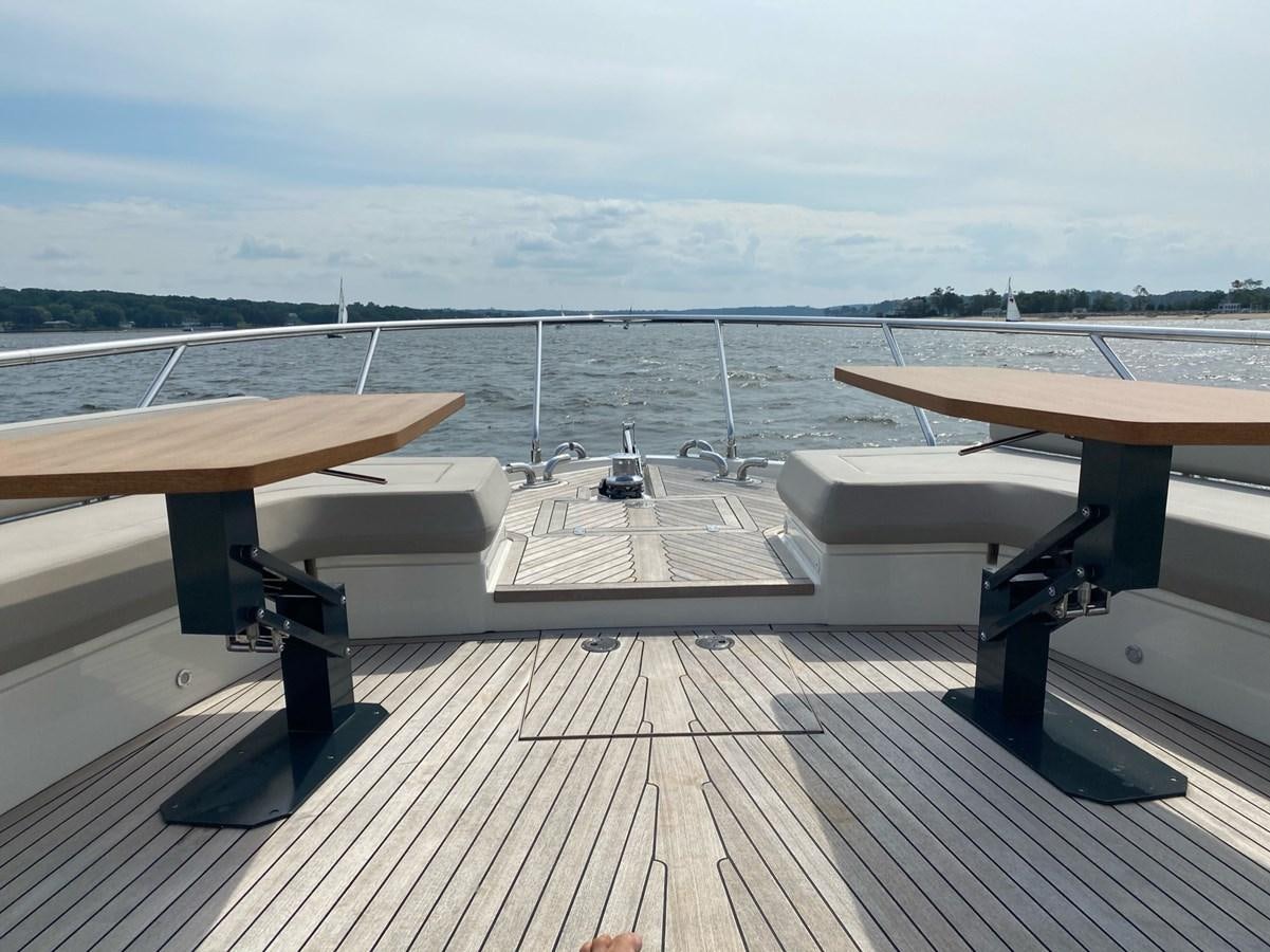 a deck with benches and a body of water in the background aboard L’ABEILLE Yacht for Sale