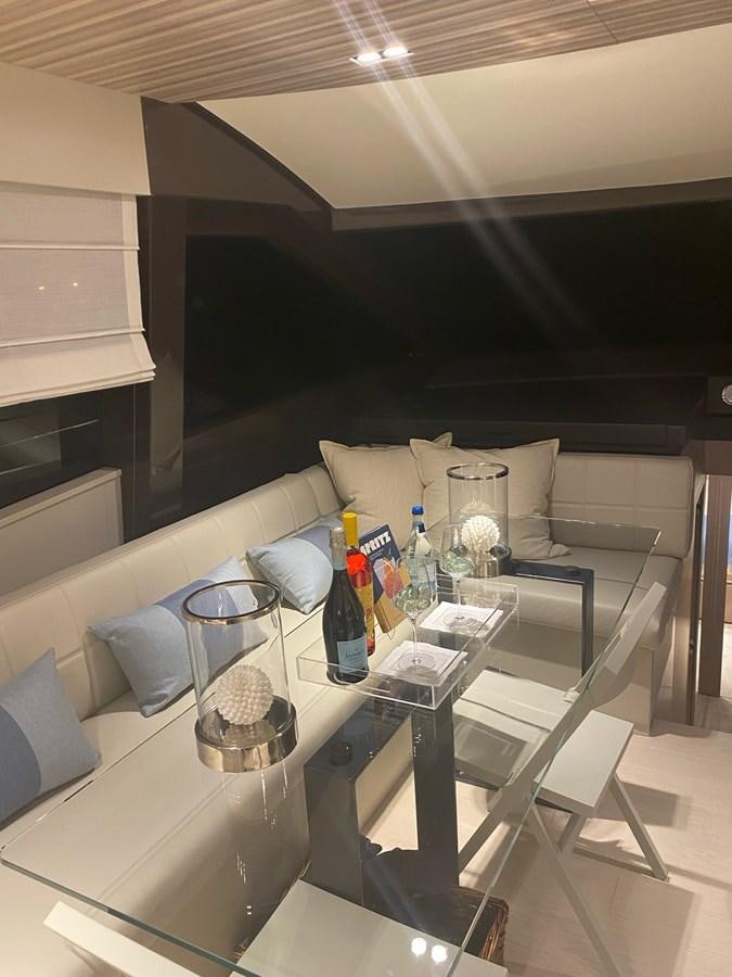 a room with a couch and a table with bottles on it aboard L’ABEILLE Yacht for Sale