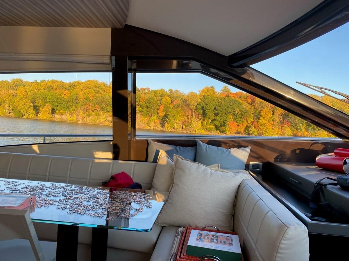 a couch and a table in a room with a window aboard L’ABEILLE Yacht for Sale