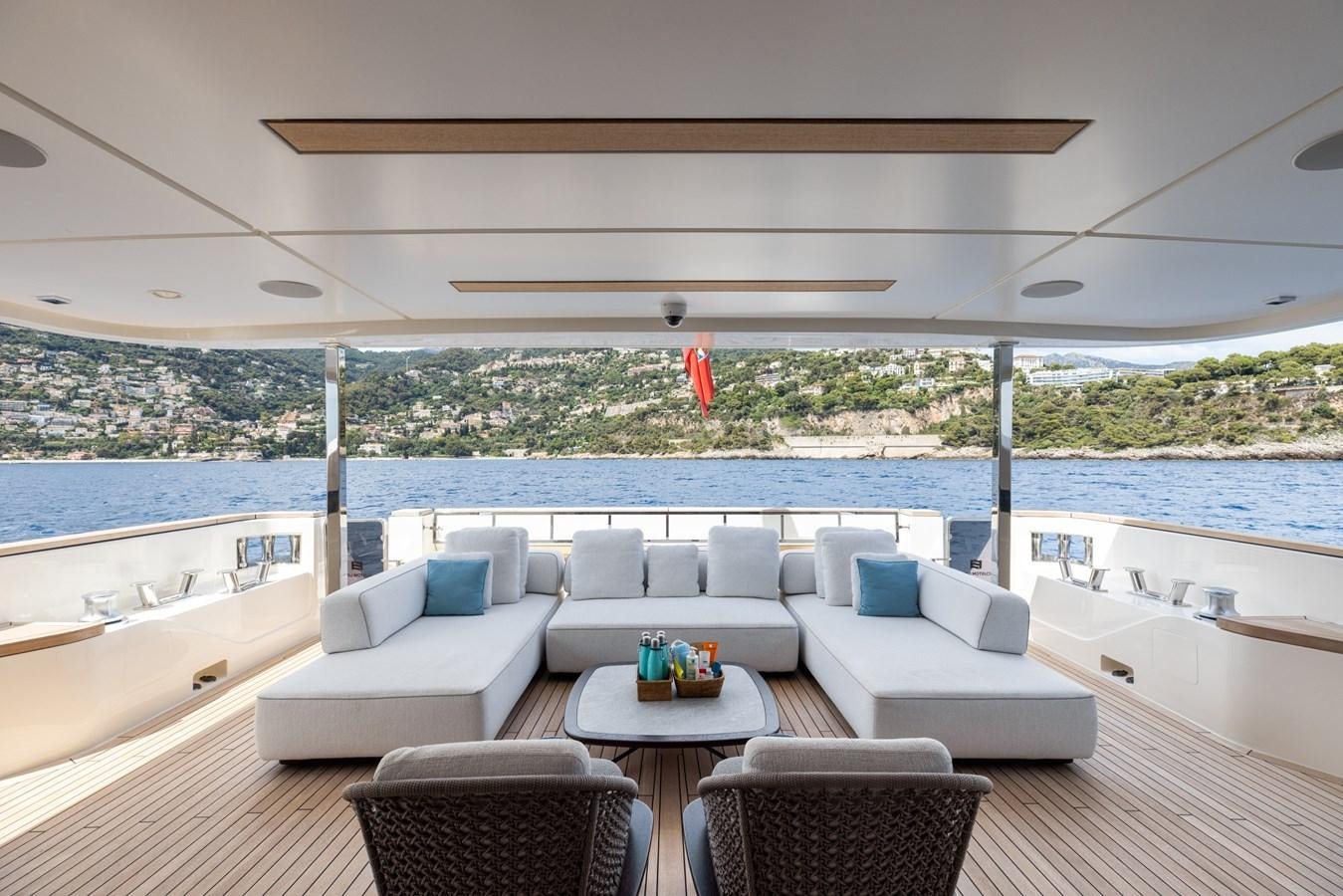 a large white lounge chair on a deck overlooking a body of water aboard EROS Yacht for Sale