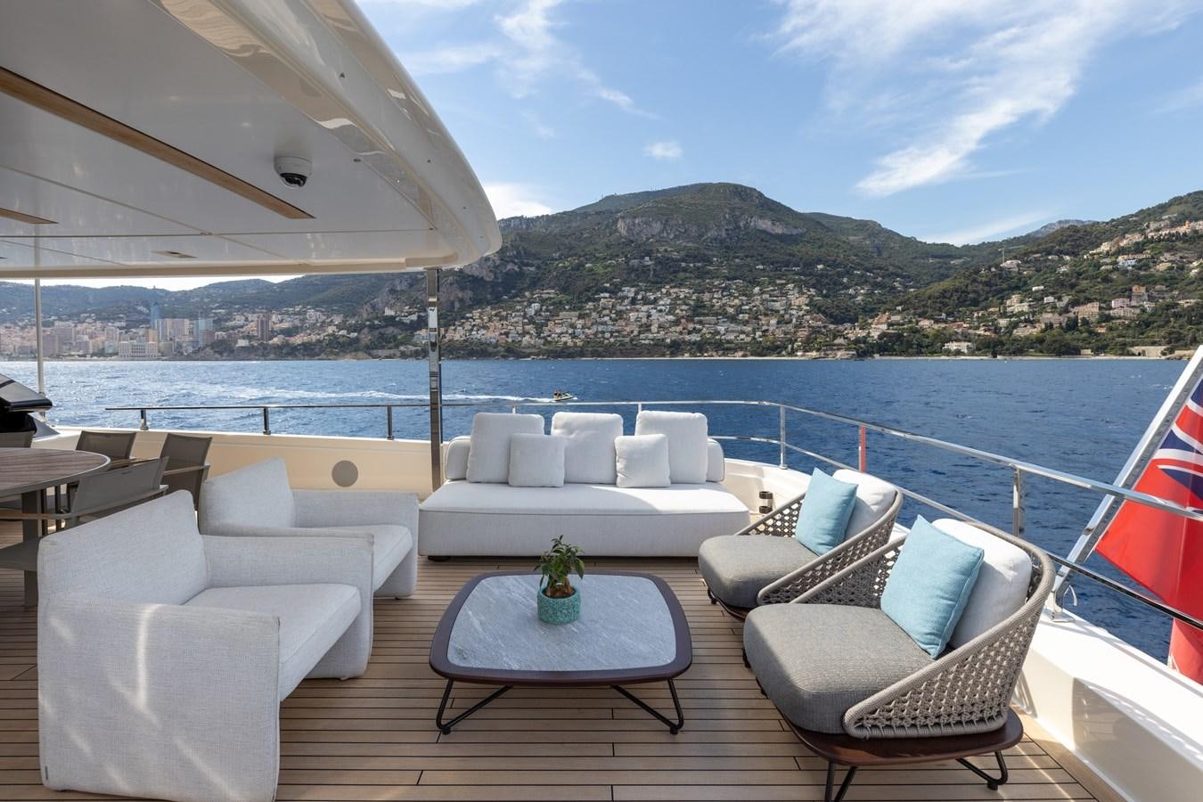 a table and chairs on a deck overlooking a body of water aboard EROS Yacht for Sale
