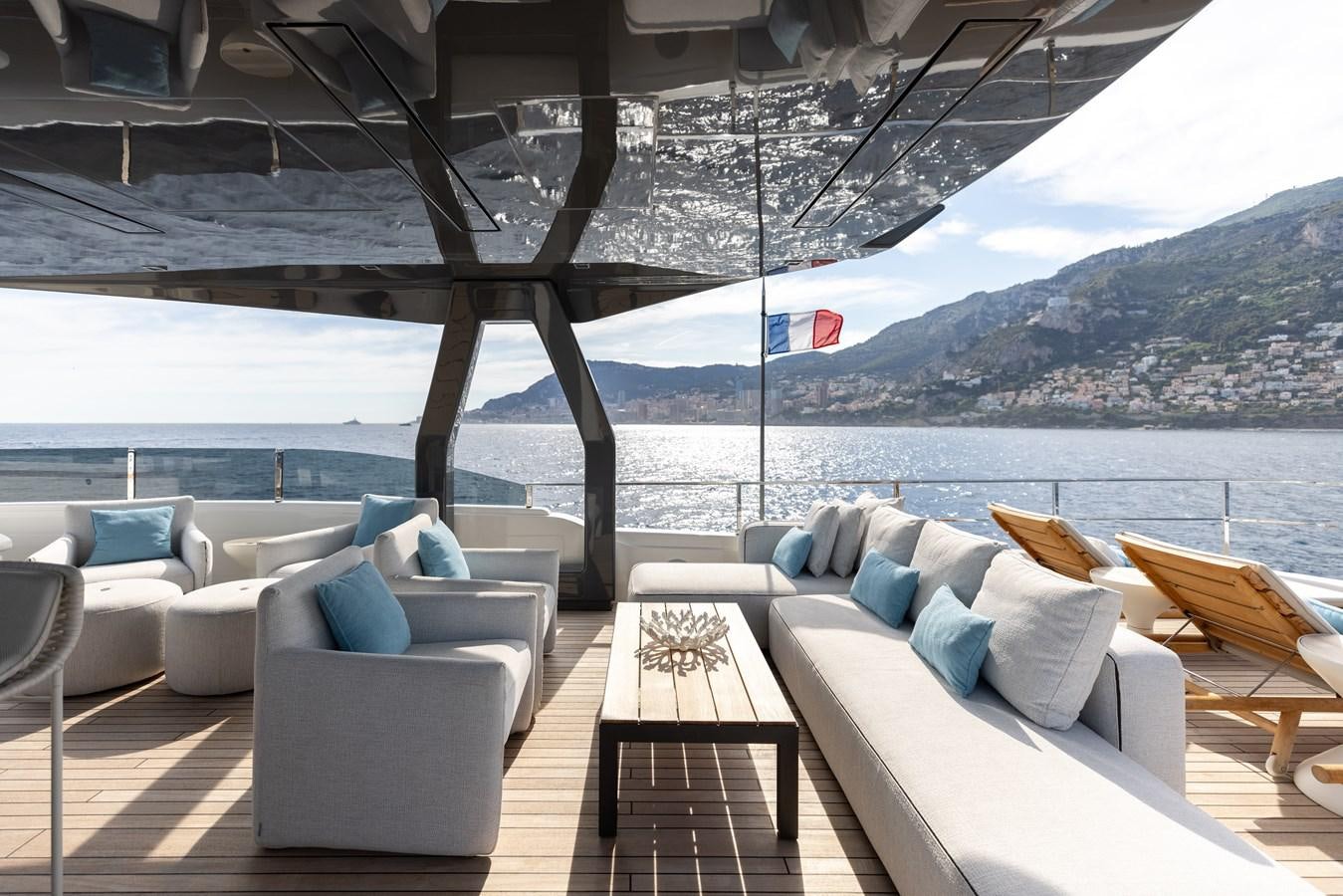 a patio with a view of a body of water and mountains aboard EROS Yacht for Sale