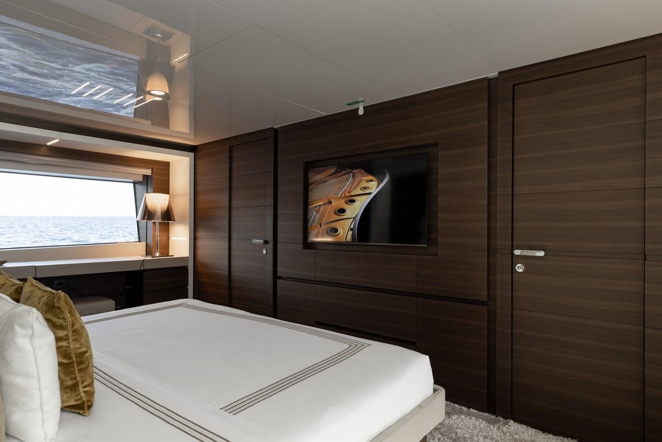 a bedroom with a bed and a television aboard EROS Yacht for Sale