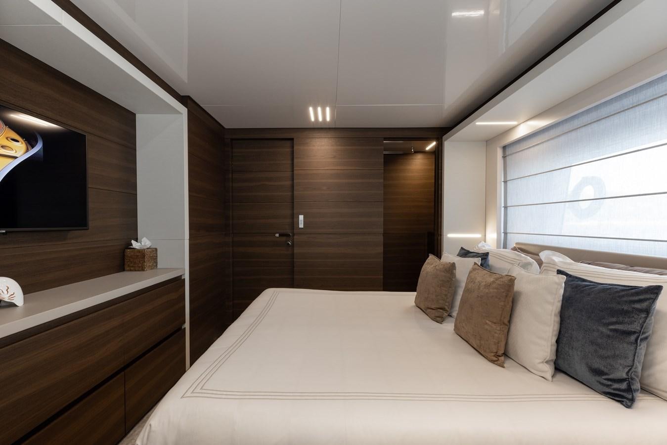 a bed with pillows and a television aboard EROS Yacht for Sale