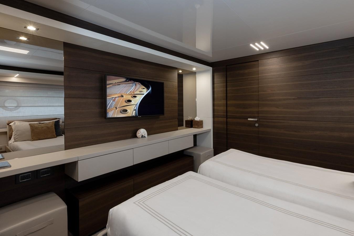 a room with a bed and a tv on the wall aboard EROS Yacht for Sale