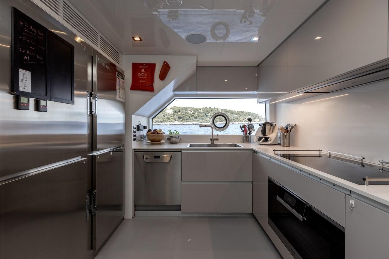 a kitchen with white cabinets aboard EROS Yacht for Sale
