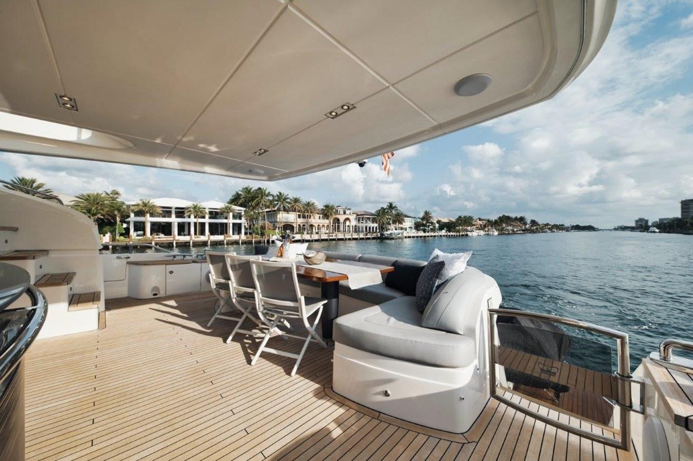 a large white lounge chair on a deck overlooking a large body of water aboard PRONTO Yacht for Sale
