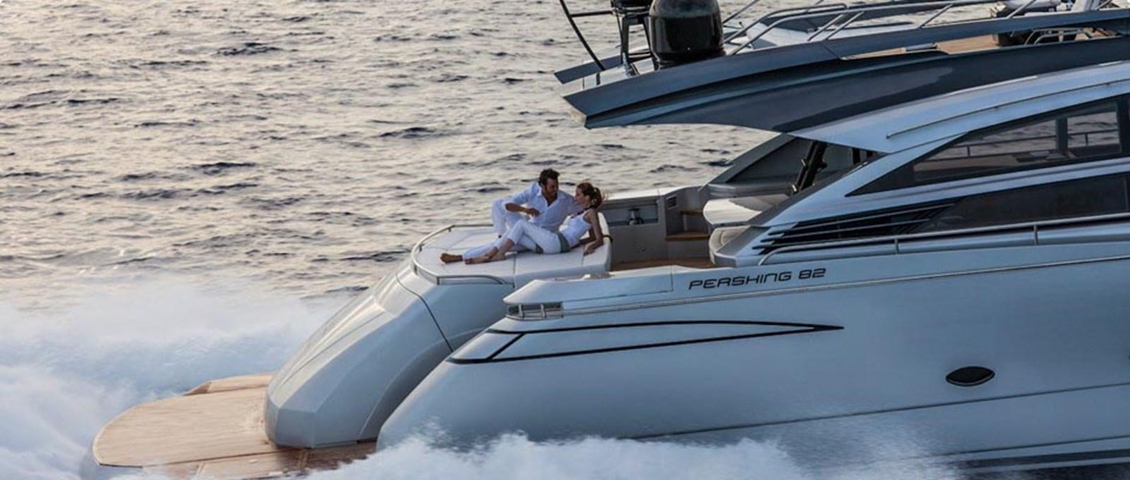 a man and woman sitting on a boat on the water aboard 2014 PERSHING 82 Yacht for Sale