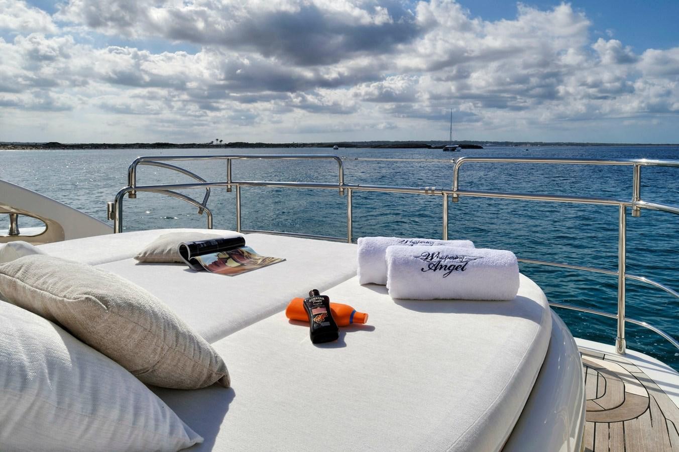 a white bed with a white pillow and a red and black object on it aboard WHISPERING ANGEL Yacht for Sale