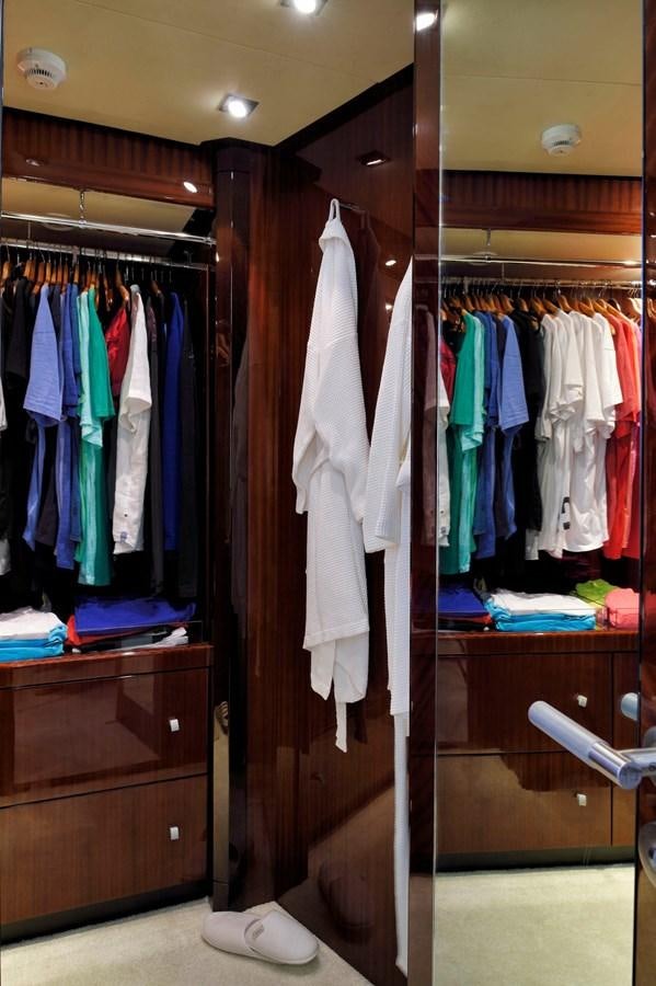 a closet with clothes on the wall aboard WHISPERING ANGEL Yacht for Sale