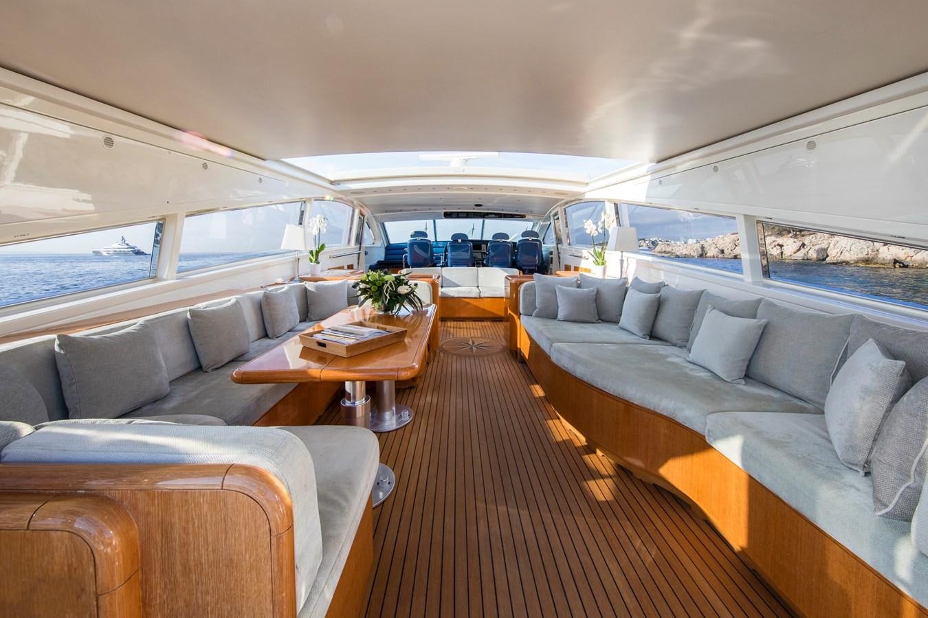 a large living room with a wood table and a large window aboard CITA Yacht for Sale