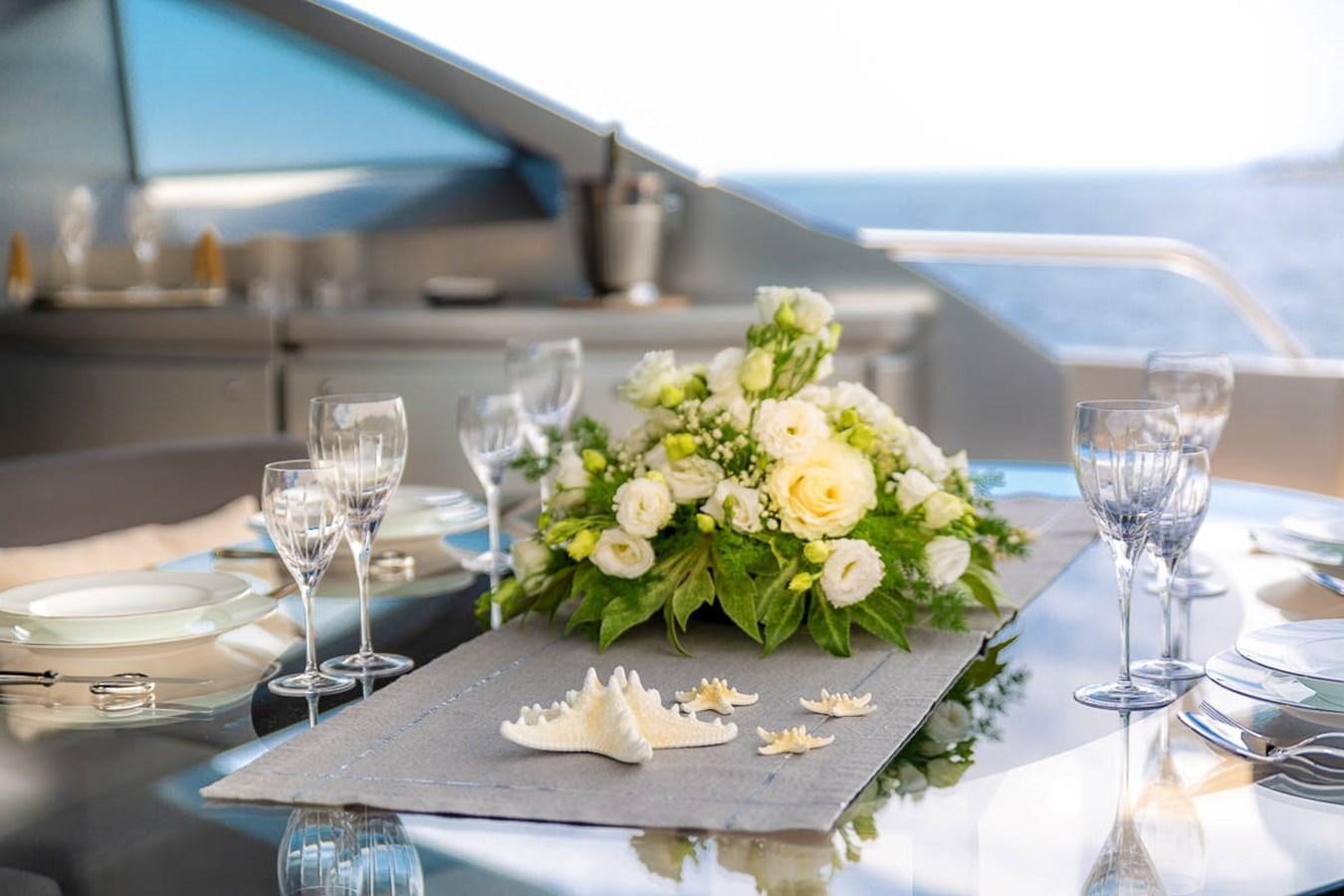 a table with a plate of food and glasses on it aboard X-TREM II Yacht for Sale