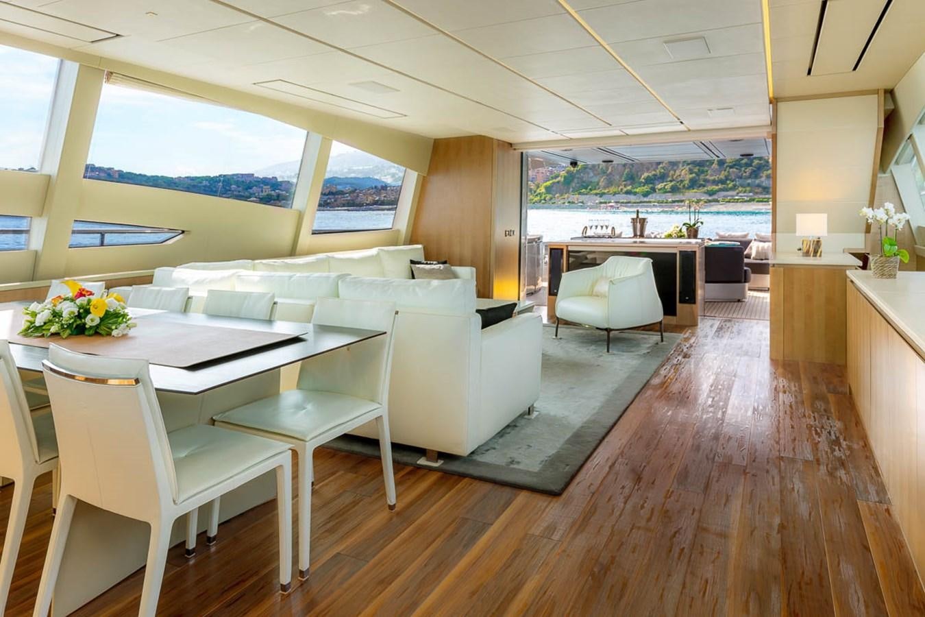 a room with tables and chairs aboard X-TREM II Yacht for Sale