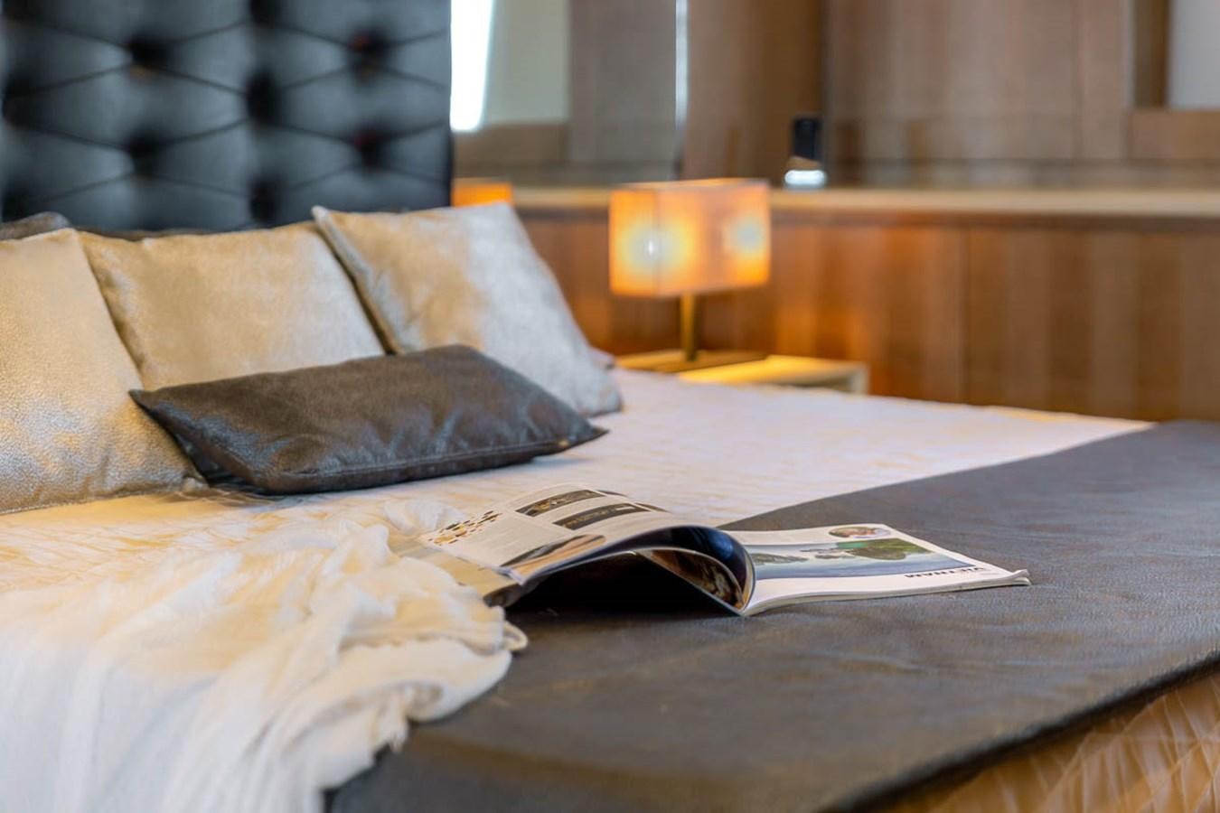 a book on a bed aboard X-TREM II Yacht for Sale