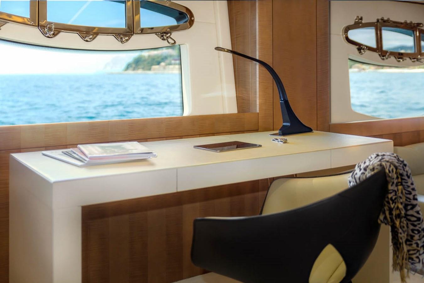 a desk with a lamp and a window aboard X-TREM II Yacht for Sale