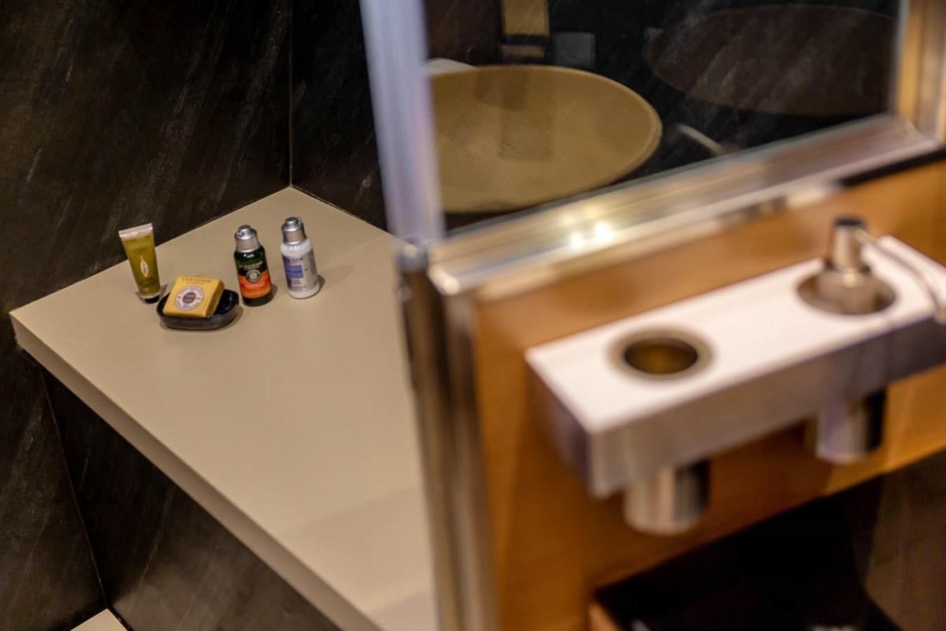 a bathroom sink with bottles on it aboard X-TREM II Yacht for Sale