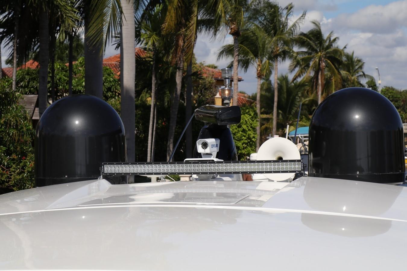 a black and white object on a surface with palm trees and a blue sky aboard VANTAGE Yacht for Sale