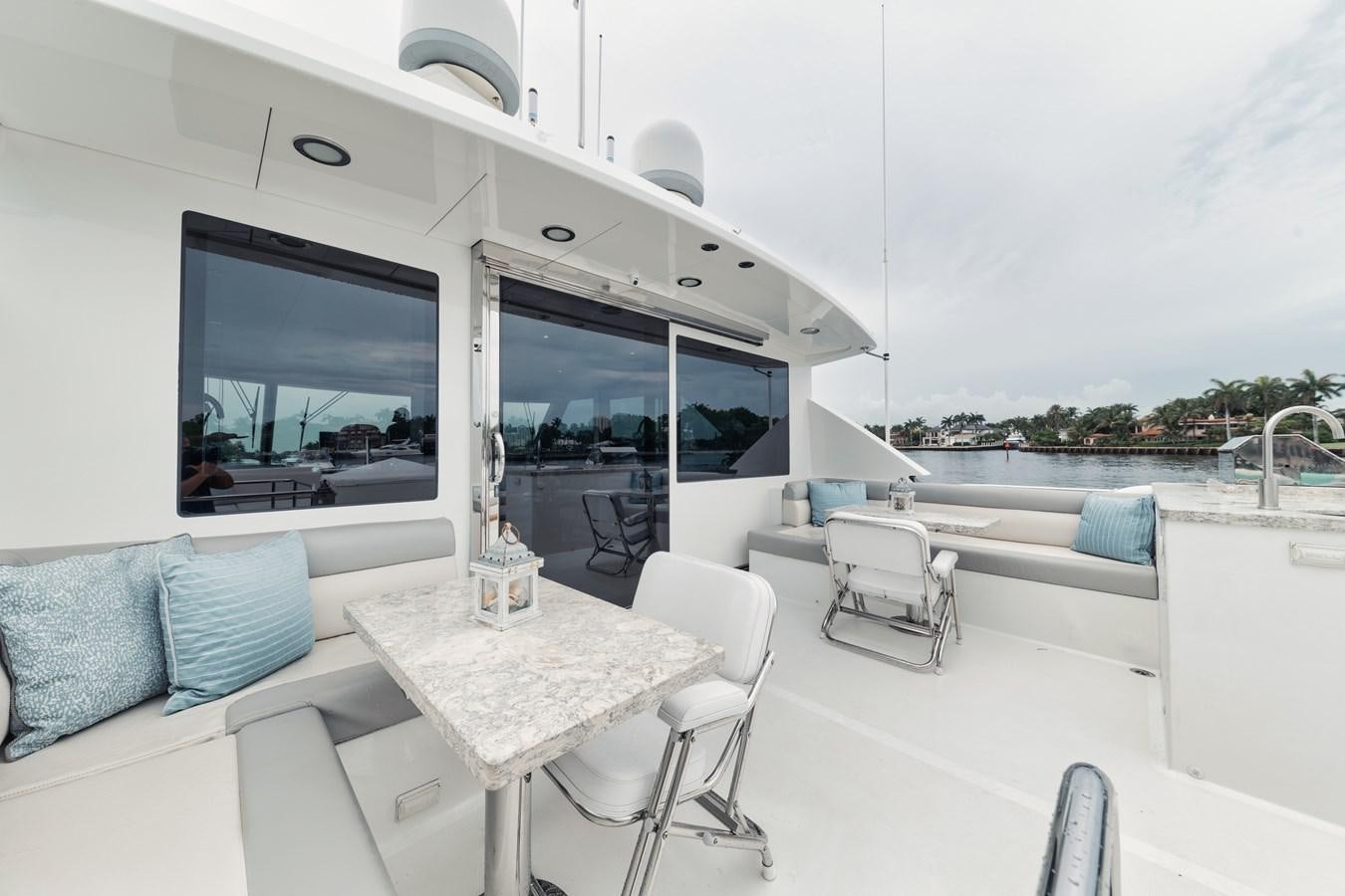 a room with a table and chairs aboard 2019 OCEAN ALEXANDER 88 SKYLOUNGE MUDSLINGER Yacht for Sale